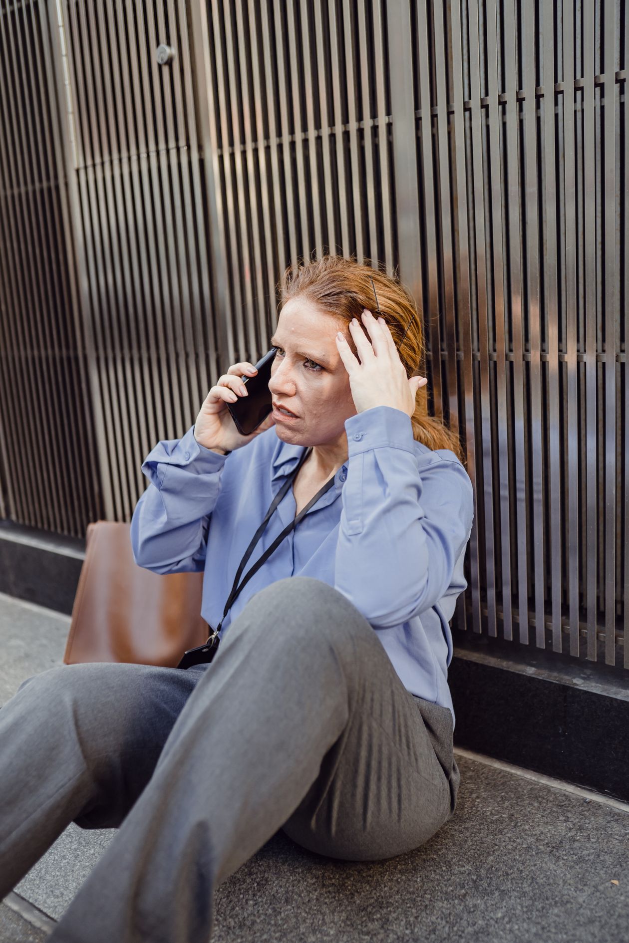 A woman looking concerned while on a phone call outdoors.