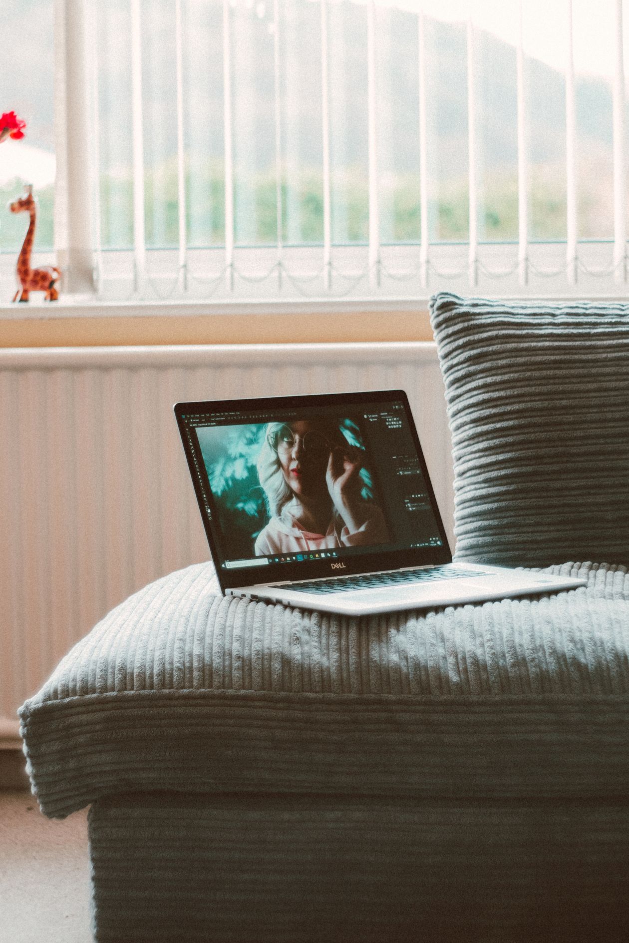A laptop open on a couch, playing a video.
