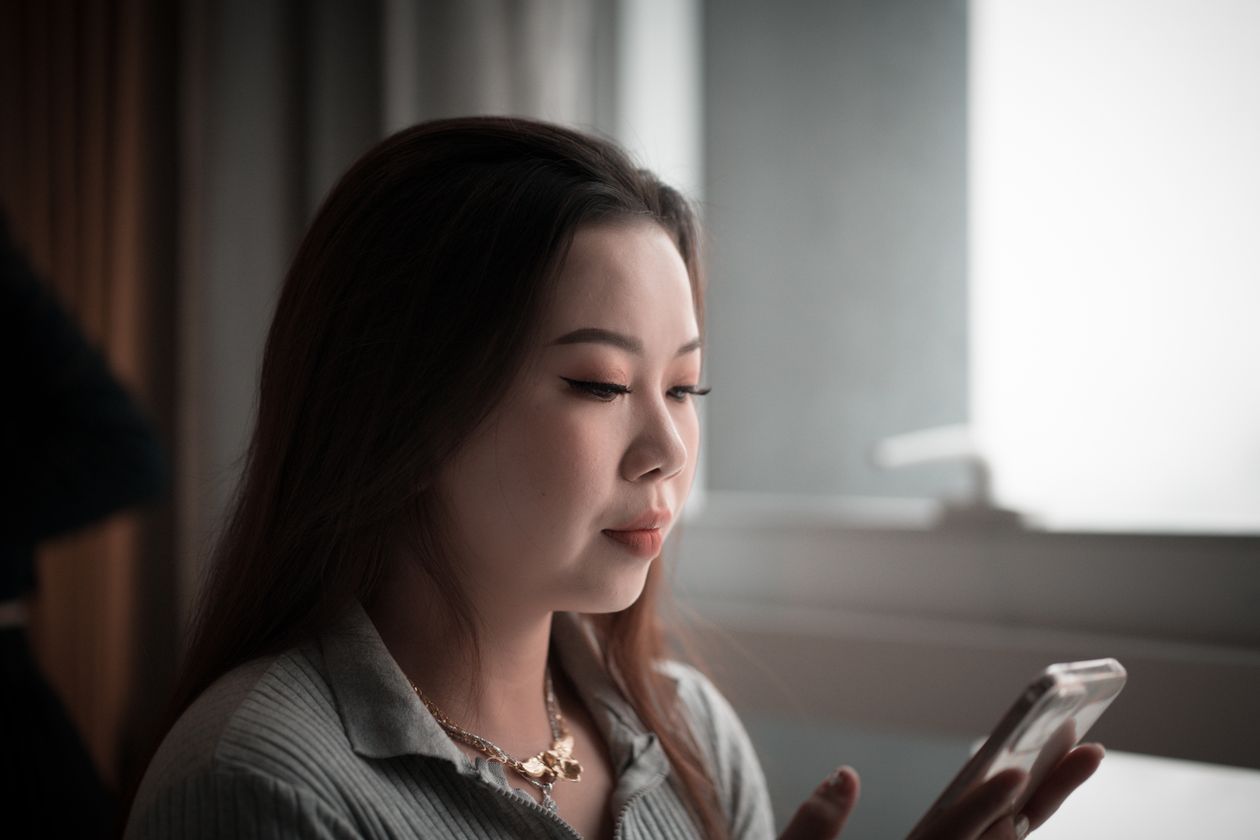 A woman looking at her phone in low light.