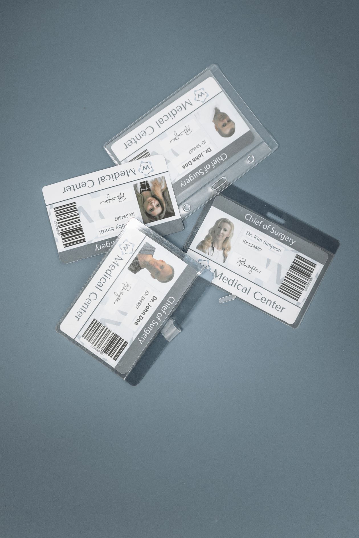 Four mock identification badges scattered on a table.