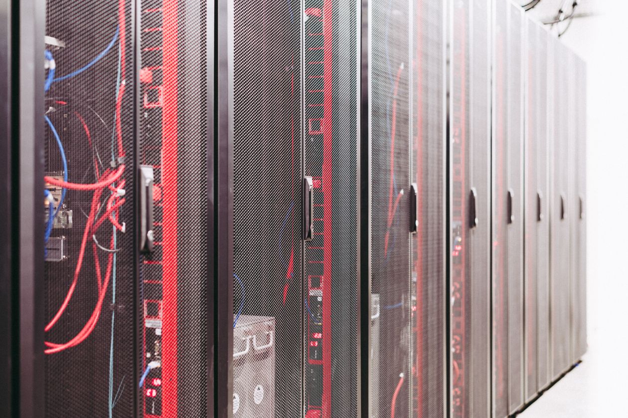 A row of server racks with red and blue cabling in a data centre.